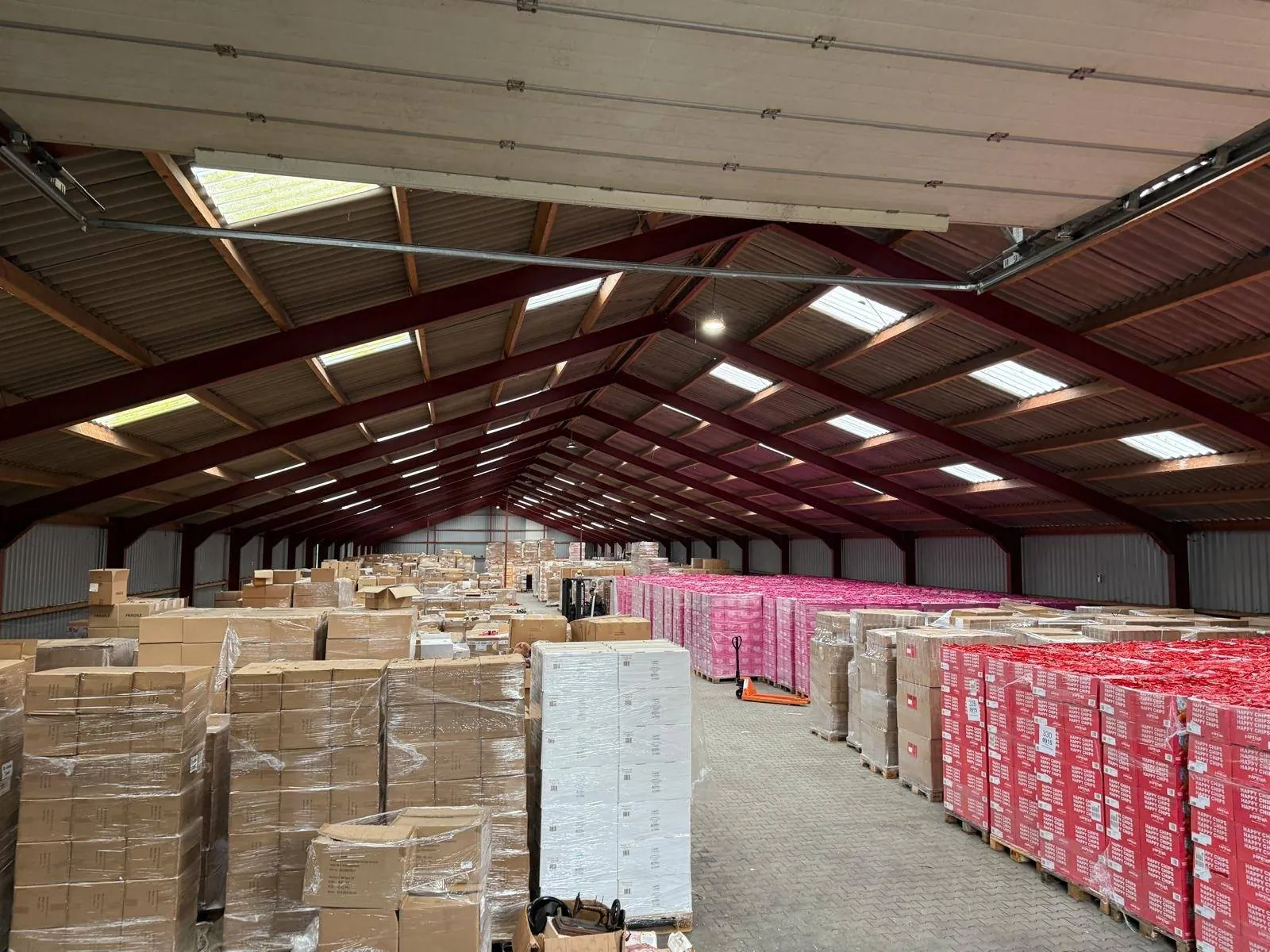Armazém cheio de paletes de batatas fritas do stock excedentário, prontas para transporte